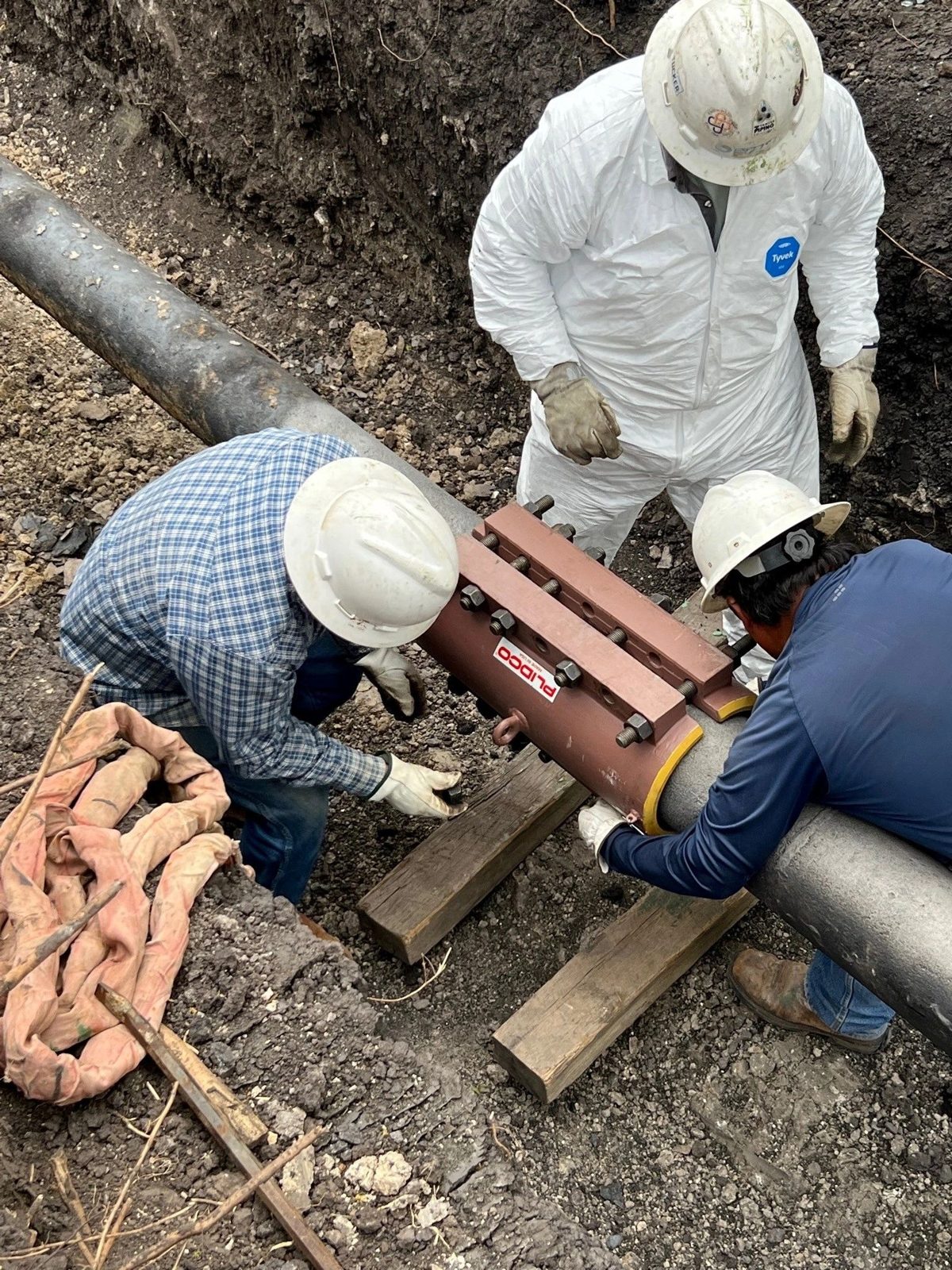 Crew installing a pipe repair sleeve